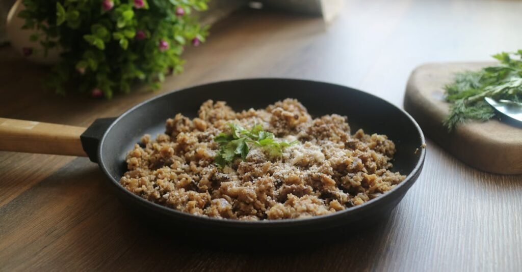 Tasty minced meat dish garnished with herbs in a black skillet, perfect for a delicious homemade meal.