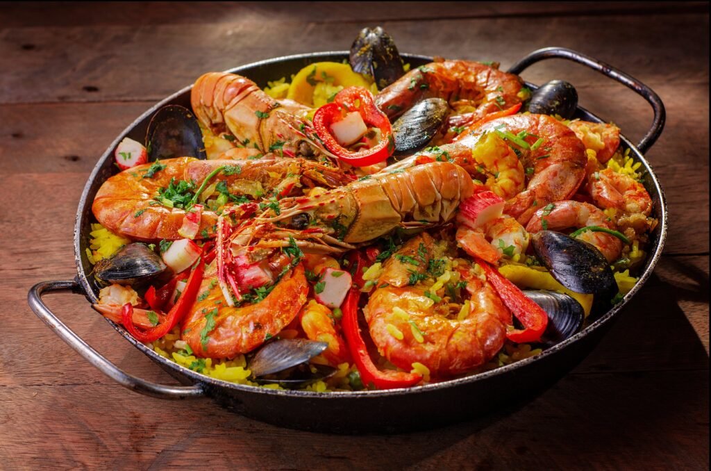 A vibrant and flavorful seafood paella served in a pan with mussels and shrimp.